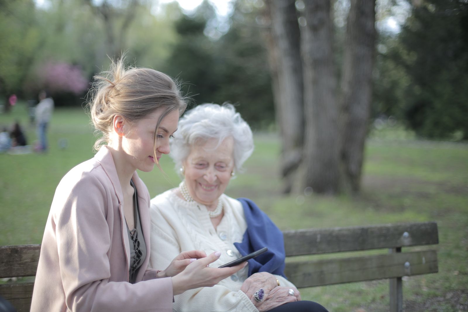 An adult daughter helping her elderly mother with a tablet at home